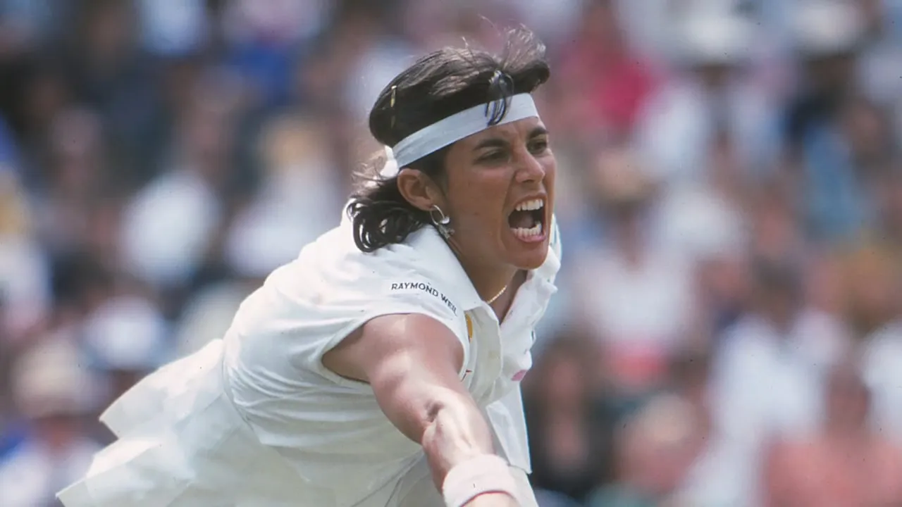 Tennis player Gigi Fernandez mid-match on a grass court.
