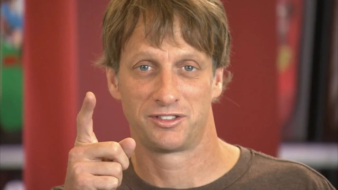 Skateboarder Tony Hawk pointing toward the camera during an interview.